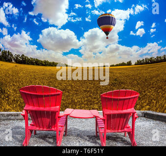 Un enorme pallone vola al di sopra di un campo Foto Stock