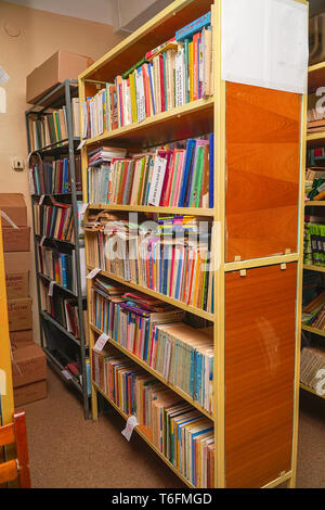 Vecchi libri su scaffali per libri in biblioteca Foto Stock