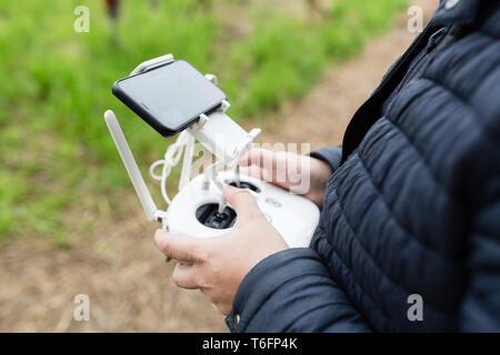 Gli uomini con le mani in mano tenendo premuto Comando remoto del drone Foto Stock