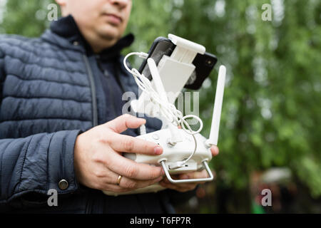 L'uomo le mani tenendo premuto Comando remoto del drone Foto Stock