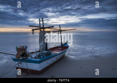 Una barca da pesca sulla spiaggia di alba Foto Stock