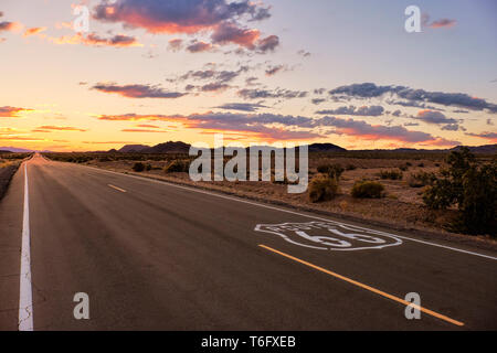 Drammatico tramonto sul percorso 66 con la strada aperta di andare nel deserto di Mojave durante una vacanza viaggio nel sud della California. Foto Stock