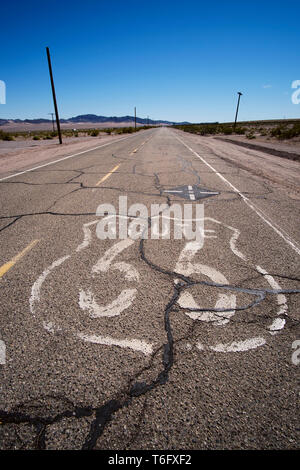 Segno della pavimentazione sulla spaccate e rotte di strada storica Route 66 nel deserto di Mojave appena fuori di Ludlow, California. Foto Stock