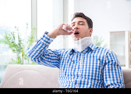 Giovane uomo che soffrono di lesioni al collo in casa Foto Stock