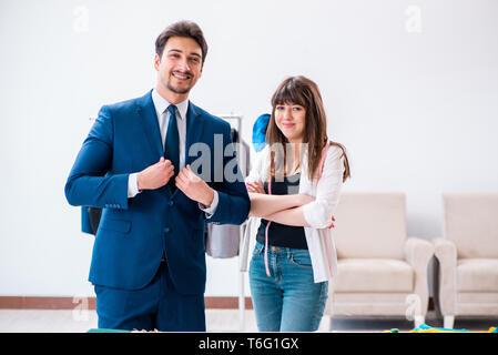 Sarto professionale prendendo le misure per tuta formale Foto Stock