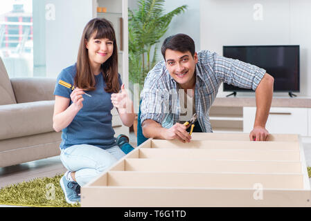 Famiglia giovane assemblaggio di mobili a casa nuova Foto Stock