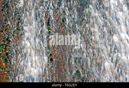 Una vista di acqua in movimento passando al di sopra di uno stramazzo. Foto Stock