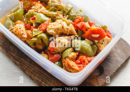 Spezzatino di pollo e verdure varie-peperoni, pomodori, zucchine in vasi di plastica per la conservazione in frigorifero o congelare Foto Stock