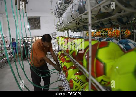 Sialkot. Xii Apr, 2019. Foto realizzata il 12 aprile 2019 illustra un lavoratore controllo pressione aria nella neo-palloni realizzati in corrispondenza di una fabbrica di calcio nella parte orientale del Pakistan Sialkot. Sialkot, una città nella provincia pakistana del Punjab, è un centro di cucito a mano il calcio rendendo nel mondo e nel suo momento di gloria, la città era una volta di catering per più di 75 percento del totale della domanda mondiale di calcio. Credito: Ahmad Kamal/Xinhua/Alamy Live News Foto Stock