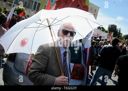 Atene, Grecia. Il 1 maggio, 2019. Un anziano protester visto con ombrello durante la manifestazione di marcatura Mayday.I dimostranti chiedono salario migliore e lavoratore i diritti. Credito: Giorgos Zachos SOPA/images/ZUMA filo/Alamy Live News Foto Stock