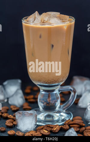 Il caffè con il latte e i cubetti di ghiaccio in un bicchiere di vetro. Foto Stock