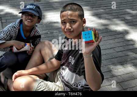 Cubo Rubik. Thailandia bambino che gioca con il cubo di Rubik e risolvendo con successo il puzzle. Foto Stock