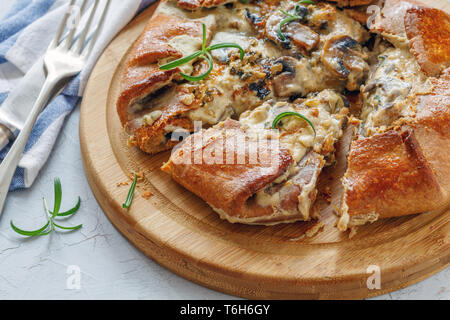 Galette con funghi e formaggio tagliato a pezzi. Foto Stock