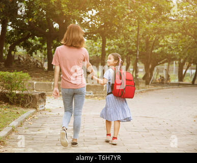 La madre e il bambino per mano di andare a scuola Foto Stock