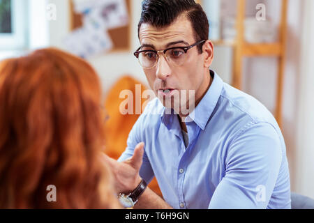 Giovane serio parlando a suo studente femmina Foto Stock