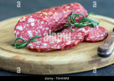 Fette di salame piccante e rosmarino. Foto Stock