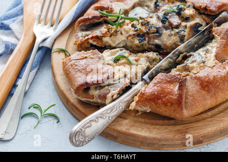 Galette con funghi e formaggio tagliato a pezzi. Foto Stock