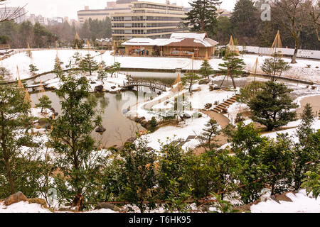 Gyokusen inmaru giardino Giapponese originariamente costruite nel 1634. Elevato punto di vista di neve coperto Giardino e parzialmente congelato stagno. Il Castello di Kanazawa, Giappone. Foto Stock