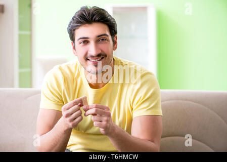 Giovane uomo a casa dopo la lesione Foto Stock