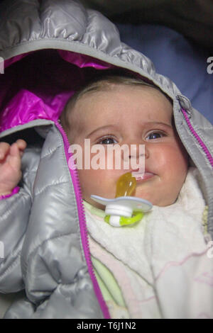 Ritratto di una incantevole piccola bambina nella camicia del bambino con il succhietto, Foto Stock
