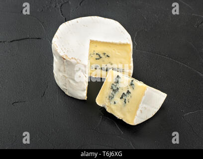 Formaggio Brie con fetta vicino sul scuro dello sfondo in calcestruzzo Foto Stock