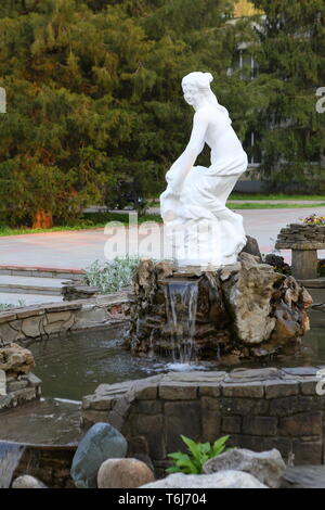 La statua della dea vicino al laghetto nel parco Foto Stock