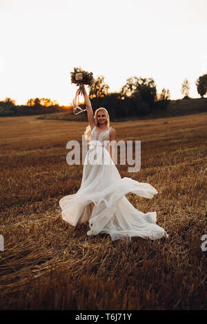 Bionda sposa azienda colorato bouquet di nozze. Foto Stock