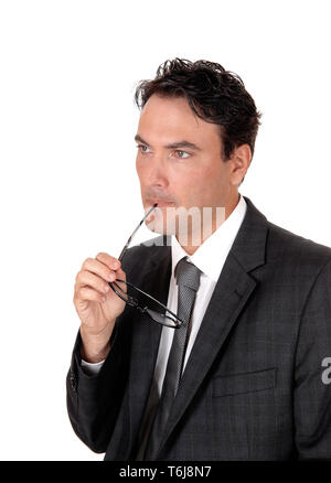 Imprenditore pensando con gli occhiali nella sua bocca Foto Stock