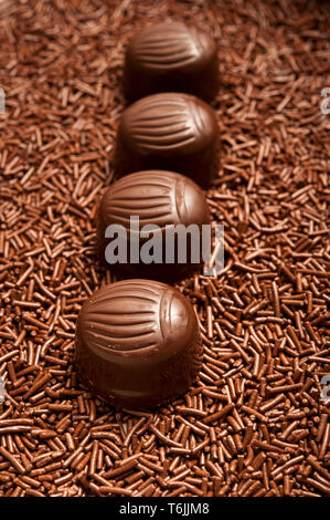 Fila di praline di cioccolato o confetti di cioccolato spruzza Foto Stock