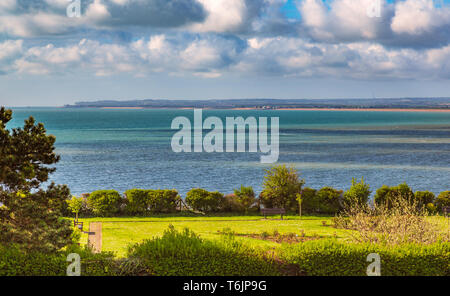 Vista sul mare verso la trattativa e Sandwich nel Kent, Regno Unito mentre il sole splende su un parco giardino di rose area del Royal Esplanade, Ramsgate. Foto Stock