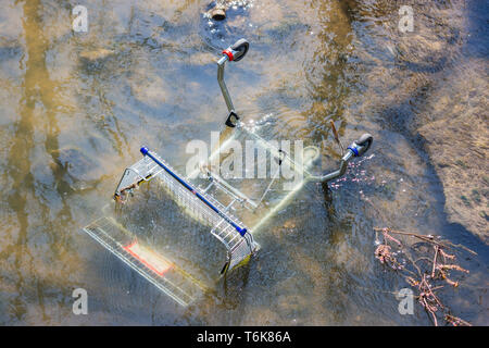 Un carrello della spesa per l'uso con una sedia a rotelle è stata thown in acque poco profonde del fiume Biss in Trowbrige e abbandonato Foto Stock