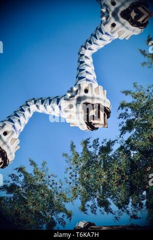 Vista astratta creata utilizzando un filtro di caleidoscopio. Gaudi camini a Park Guell trasformarsi in un mostro airborne. Barcellona, Spagna. Ottobre 2018. Foto Stock