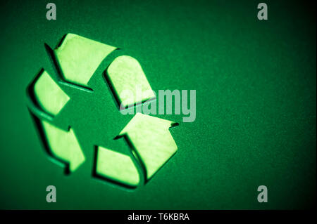Chiusura del simbolo di riciclaggio in rilievo sulla tessitura liscia sfondo verde Foto Stock