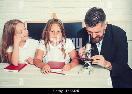 Tempo di scuola di suore e padre. Si torna a scuola e la scuola. Lezione di biologia e lo studio in laboratorio con microscopio. Istruzione nella conoscenza Foto Stock