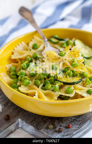 Piastra con pasta, zucchine e piselli verdi. Foto Stock