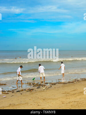 Isola di Bali, Indonesia - 03 Aprile 2017: gruppo di persone la pulizia spiaggia dalla spazzatura e rifiuti in plastica. Foto Stock