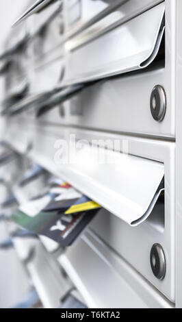 Metallo moderno caselle di posta piena di volantini Foto Stock