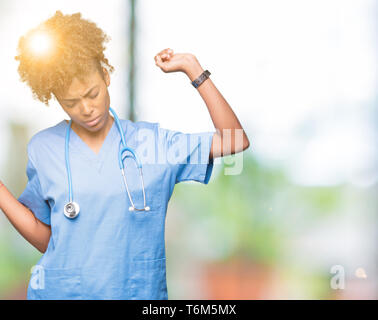 Giovane africano medico americano donna sullo sfondo isolato Stretching schiena, stanco e rilassato, assonnato e sbadigli per la mattina presto Foto Stock