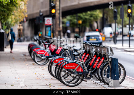 London, Regno Unito - 12 Settembre 2018: molti cicli di Santander red affitto biciclette parcheggiate all docking station nel centro cittadino in fila da street Foto Stock