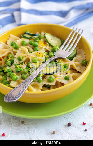 Farfalle tradizionale pasta con zucchine e piselli verdi. Foto Stock