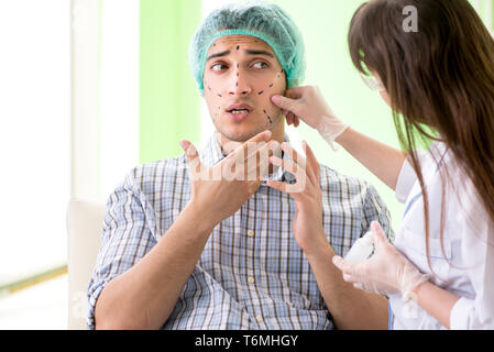 Chirurgo di plastica la preparazione per il funzionamento sul viso uomo Foto Stock