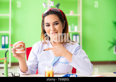 Donna dentista lavora sui denti impianto Foto Stock