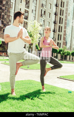 Concentrato uomo barbuto in piedi in posa di yoga Foto Stock