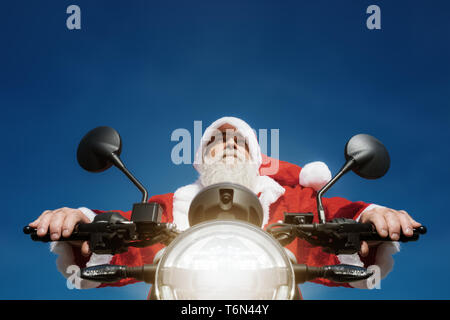 Un uomo su una moto in una tipica Santa Claus costume Foto Stock