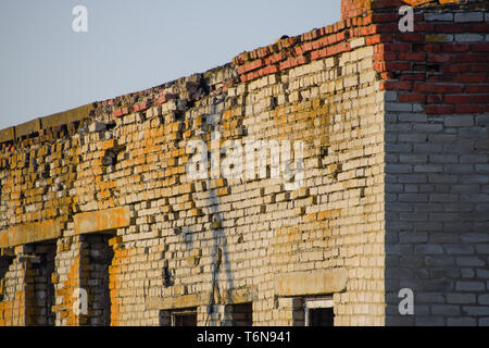 Vecchio mattone sovietica edificio abbandonato. Collassare costruzione in mattoni. Il bianco e il rosso mattone Foto Stock