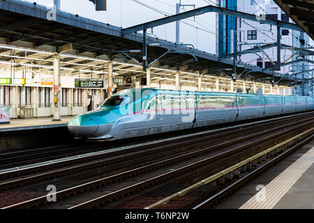 Utsunomiya, Giappone - Aprile 5, 2019: Stazione ferroviaria piattaforma con il treno superveloce shinkansen di notte la sera con le vie Foto Stock