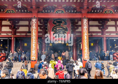 Tokyo, Giappone - 30 Marzo 2019: Il quartiere di Asakusa area con fasi di ingresso esterno al tempio di Sensoji santuario con architettura rosso e la folla di persone Foto Stock