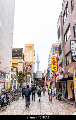 Tokyo, Giappone - 30 Marzo 2019: area di Asakusa con skytree torre vista verticale in downtown area sul giorno nuvoloso e turisti gente camminare da negozi Foto Stock