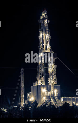 Campo dell'olio. Impianto di perforazione durante la notte. Foto Stock