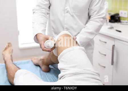 Ortopedico del bendaggio gamba del paziente in ospedale Foto Stock